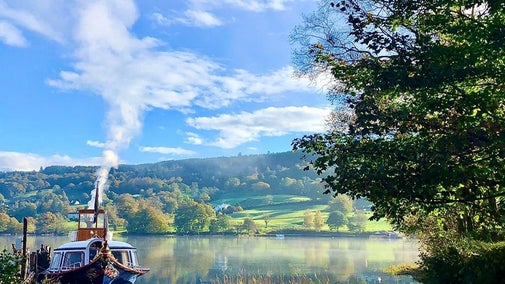An autumnal scene showing the jetty and Gondola steaming ready for the day ahead with autumnal colours in the hills in the background